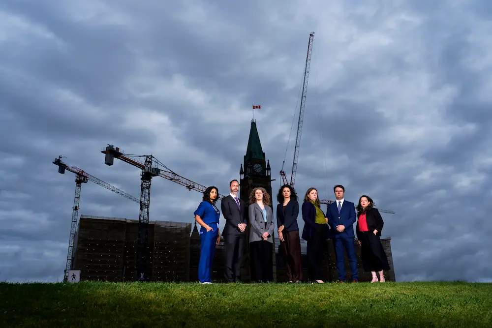 shirley posing for a photo with other advocates near a shipyard