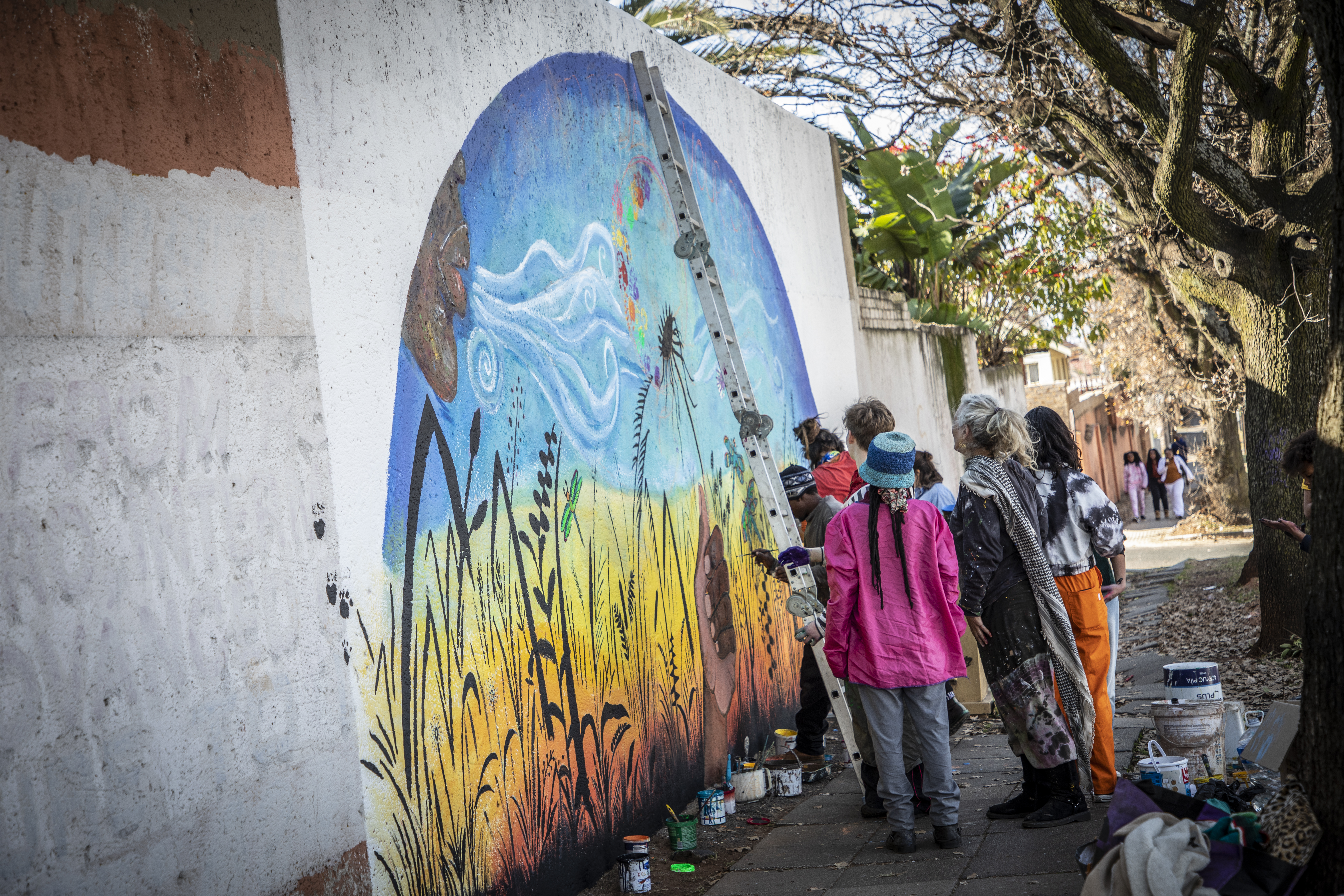 People painting a mural on a building