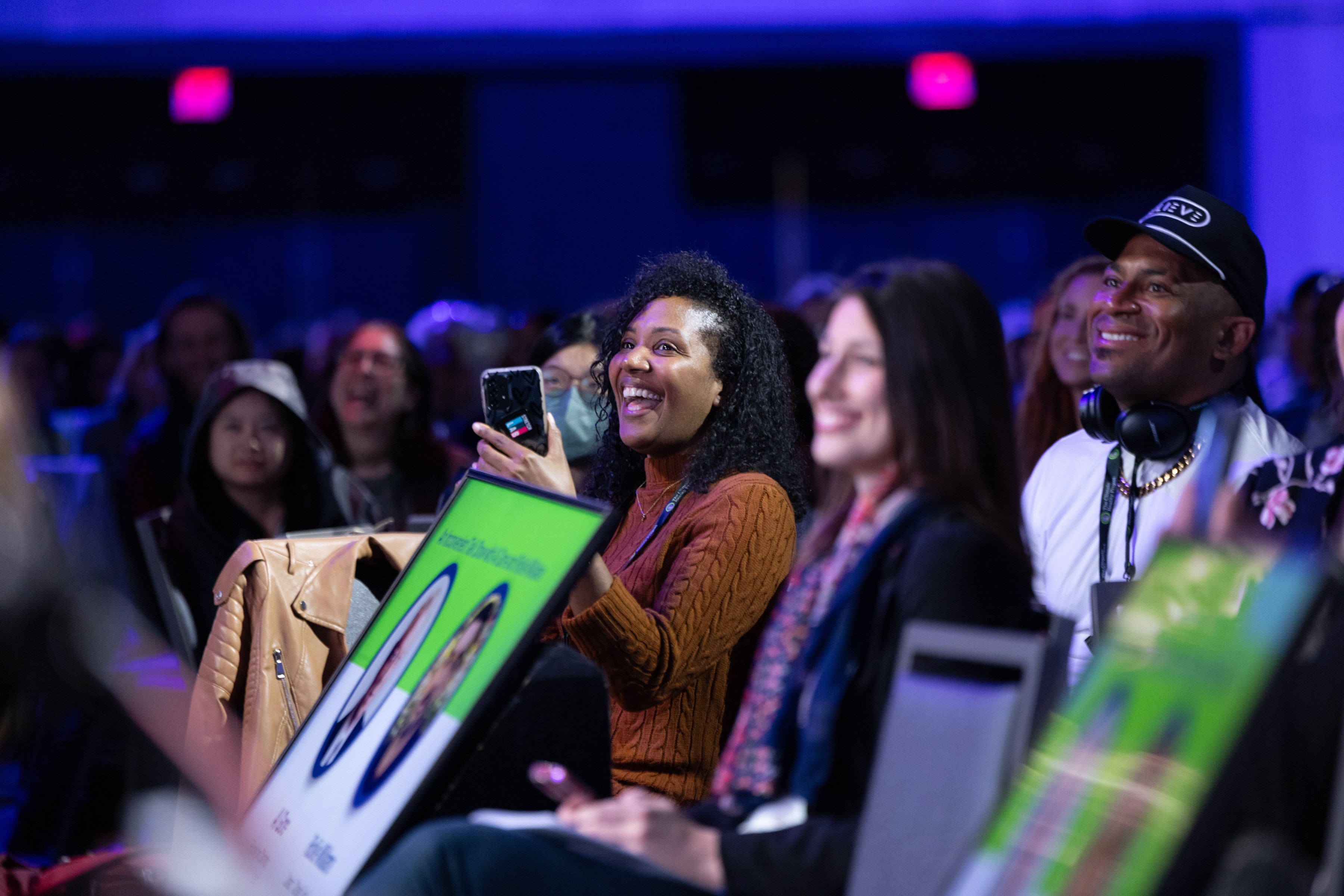 training attendee enjoying a presentation in her seat among the crowd