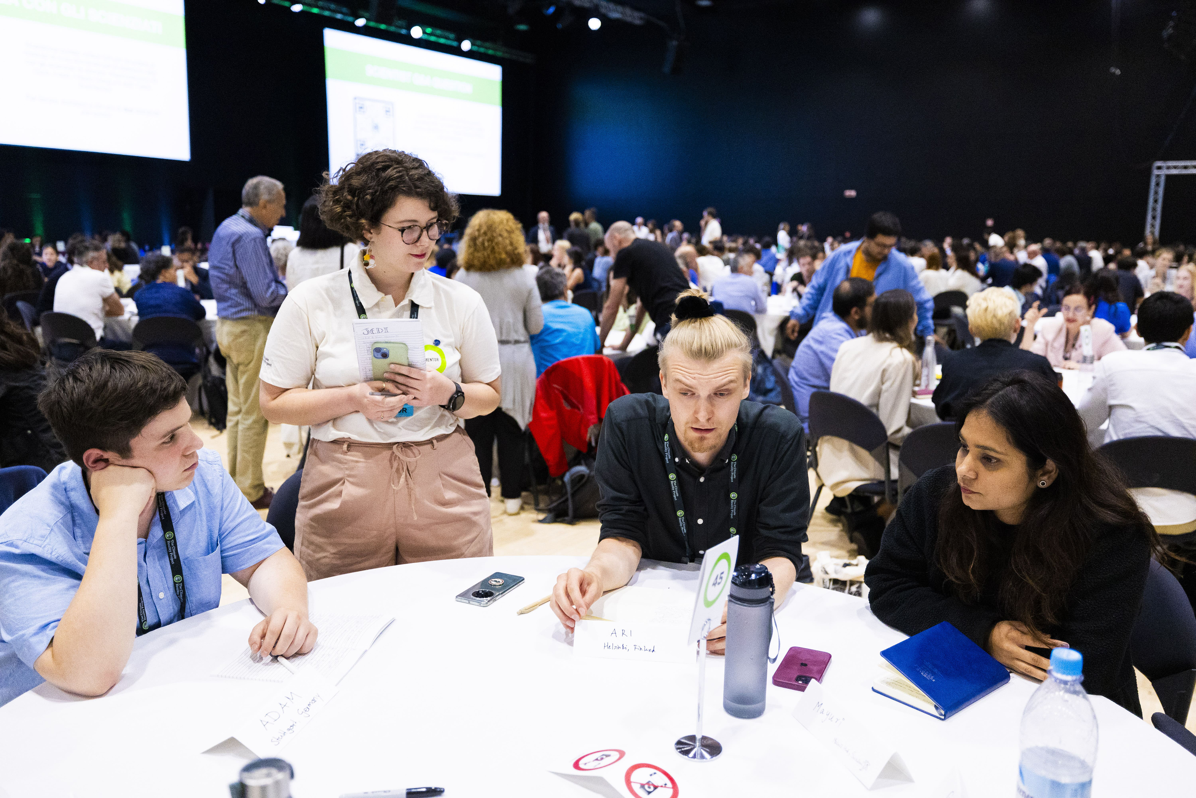 attendees gather at a table to discuss ideas