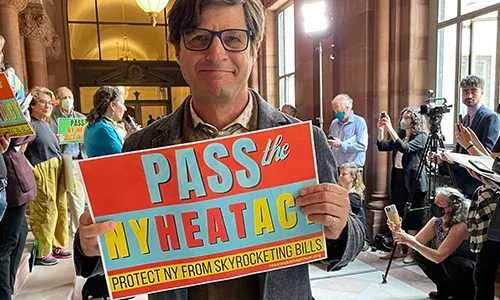 man holding sign for climate progress