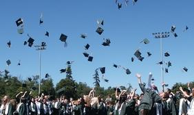 Students celebrating graduation by throwing hats into the air