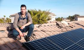 Jonathan Scott near solar panel on roof