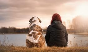 Woman and Dog by lake at sunset