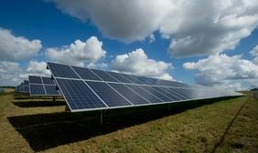 Solar Panels under a bright blue cloudy sky 