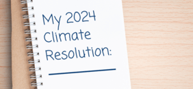 A notebook with writing that reads "My 2024 Climate Resolution"