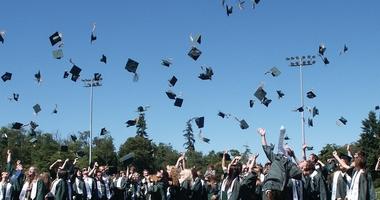 Students celebrating graduation by throwing hats into the air