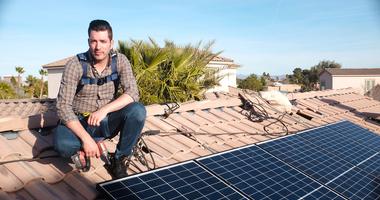 Jonathan Scott near solar panel on roof
