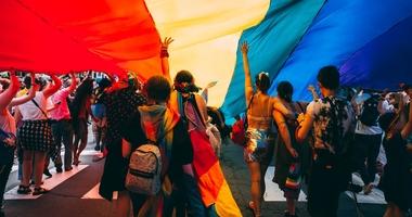 group of people under rainbow garment