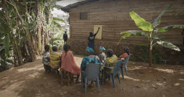 Giving a local presentation in a tropical home in Cameroon