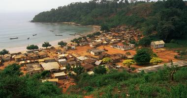 Aerial view of a city in Ghana in a forest by a body of water