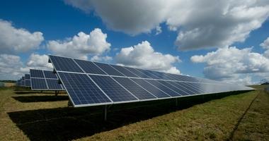 Solar Panels under a bright blue cloudy sky 