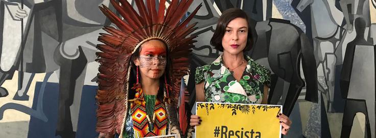 Women holding signs that say resist
