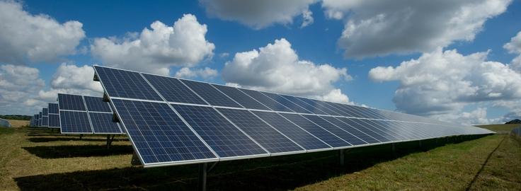 Solar Panels under a bright blue cloudy sky 