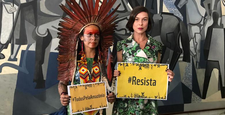 Women holding signs that say resist