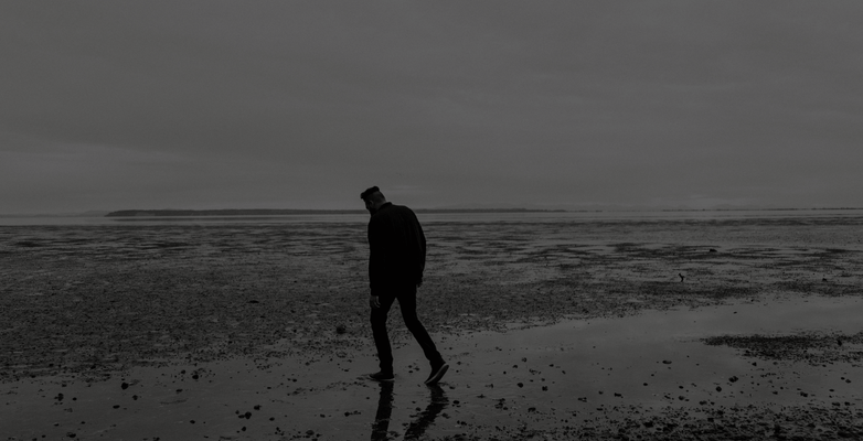 Man Walking on dreary beach