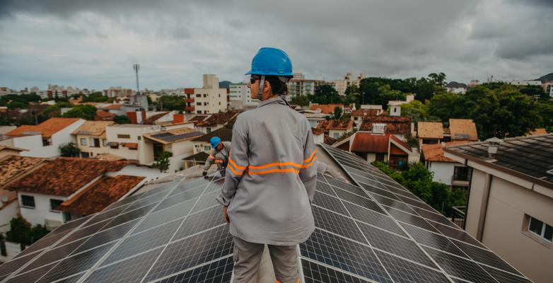 woman on roof installing solar panel