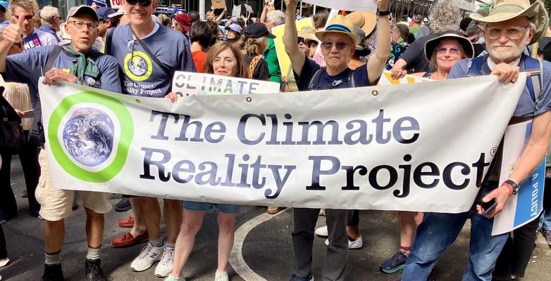 crowd with climate reality sign at a rally