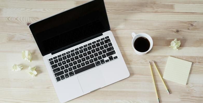 Computer with pencils and cup of coffee