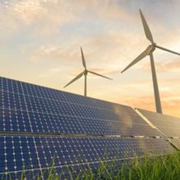 solar panels in front of a windfarm
