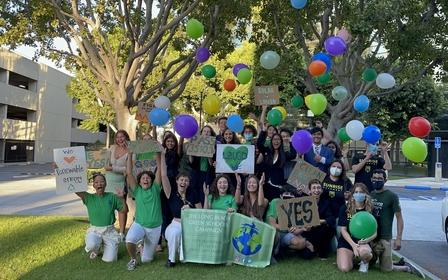 youth activists surrounded by balloons huddle for group photo